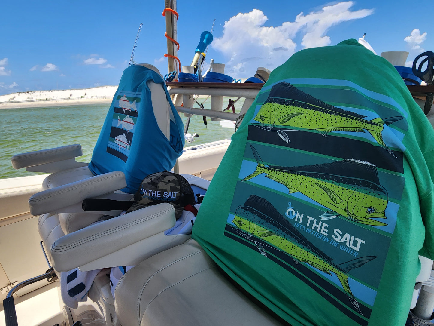 T shirts with fish design and 'On The Salt' branding on a boat.