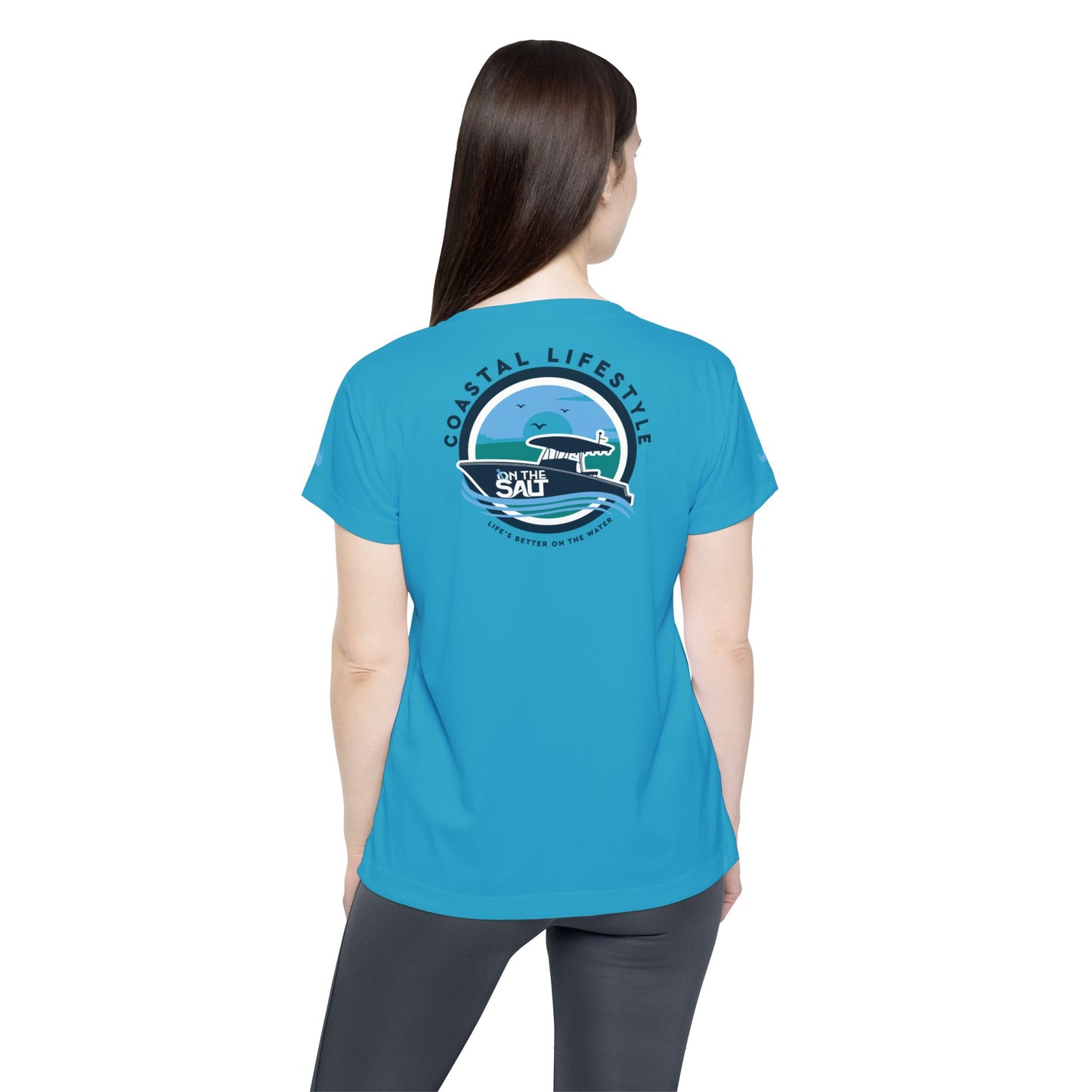 Person wearing a blue t-shirt with a graphic design on the back, standing against a white background