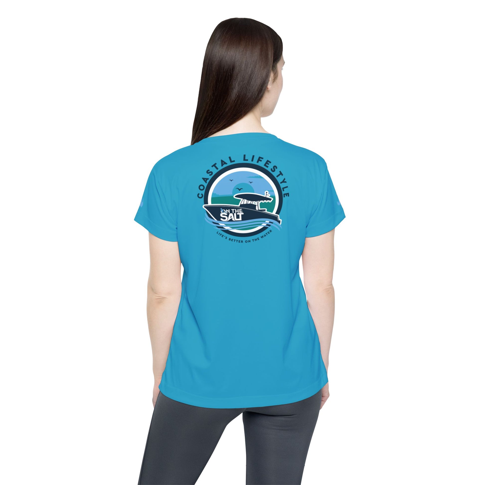 Person wearing a blue t-shirt with a graphic design on the back, standing against a white background